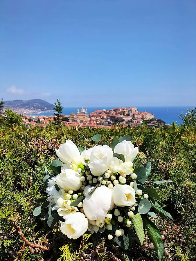 Bouquet bianco di tulipani e bacche sulla macchia verde, con Imperia e il mare sullo sfondo