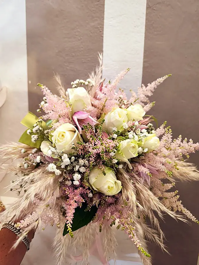 Bouquet da sposa di rose bianche, astilbe rosa e pampas