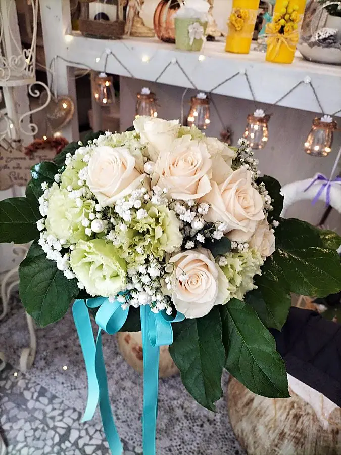 Bouquet da sposa di rose color crema e lisianthus verdi con perle e nastro turchese