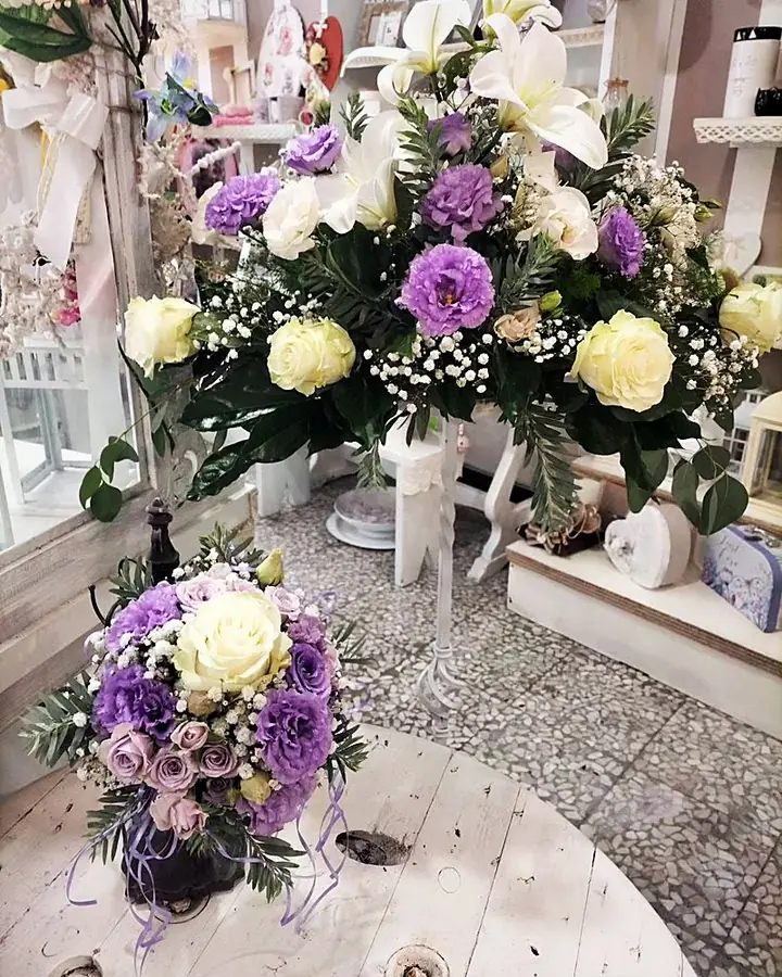 Bouquet e centrotavola alto di lisianthus lilla, rose e gigli bianchi