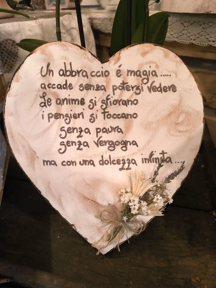 Cuore di legno con frase sull’abbraccio scritta a mano e piccolo mazzo di fiori secchi e lavanda