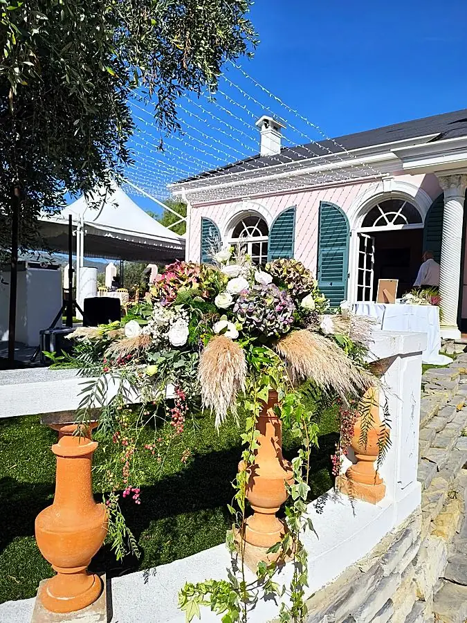 Grande composizione di ortensie, pampas ed edera sulla balaustra di una villa