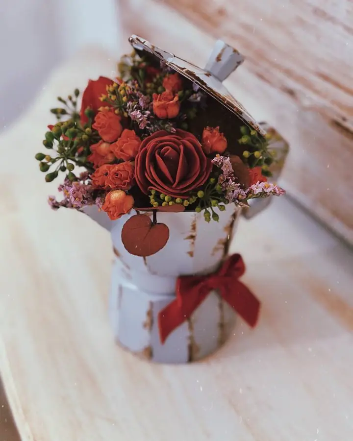 Moka trasformata in vaso con fiori rossi e arancio